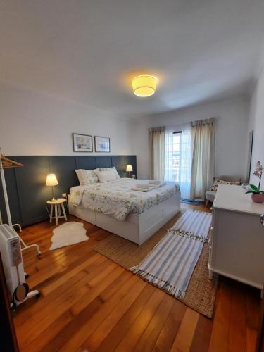 ein Schlafzimmer mit einem großen Bett und Holzböden in der Unterkunft Casa das Camélias in Aveiro