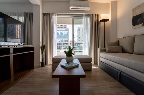 uma sala de estar com um sofá e uma mesa em Barrancas Quality Apartments em Buenos Aires