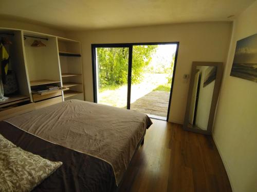 1 dormitorio con 1 cama y puerta corredera de cristal en Villa climatisée piscine, en Cadenet