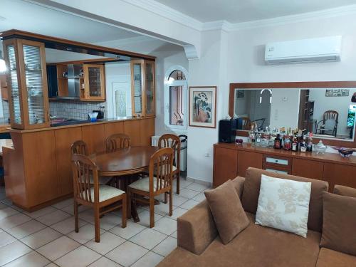 a kitchen and living room with a table and a couch at Villa Marina in Liapades
