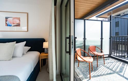a bedroom with a bed and two chairs on a balcony at Sea Eagles Landing by Revelstoke Vacations in Revelstoke