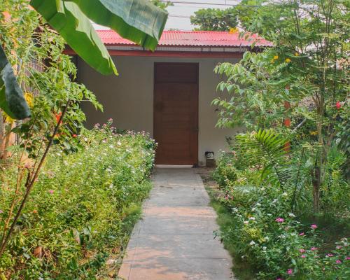 a garden path leading to a house with a door at Casa Albina in Yurimaguas