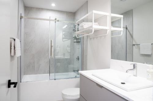 a white bathroom with a shower and a sink at Sea Eagles Landing by Revelstoke Vacations in Revelstoke