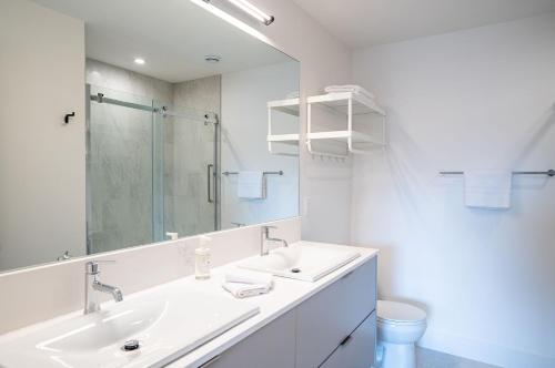 a white bathroom with a sink and a mirror at Sea Eagles Landing by Revelstoke Vacations in Revelstoke