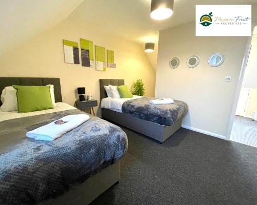 um quarto com 2 camas e almofadas verdes em 3 Bedroom 2 Bath House By Passionfruitproperties Close To Coventry City Centre - Free Wi-Fi, Driveway And Garden - 8RWC em Coventry
