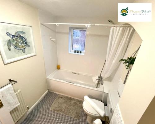 uma pequena casa de banho com WC e banheira em 3 Bedroom 2 Bath House By Passionfruitproperties Close To Coventry City Centre - Free Wi-Fi, Driveway And Garden - 8RWC em Coventry