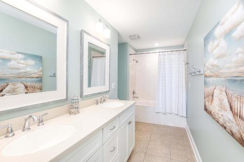 een badkamer met 2 wastafels en een grote spiegel bij Beach House 413 in Tybee Island