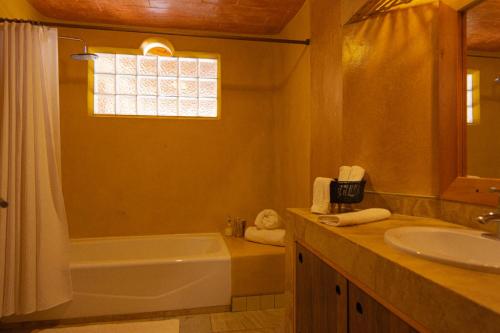 a bathroom with a bath tub and a sink at El EQUIMITE HOTEL BOUTIQUE in Coatepec