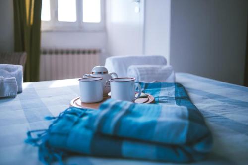 a table with two cups on a blue table cloth at Albergo delle Ondine in Tellaro