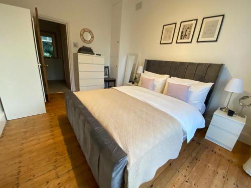 a bedroom with a large bed with white sheets and pillows at Beautiful one bed garden flat in Muswell hill in London