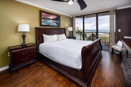 1 dormitorio con 1 cama grande y balcón en Nautilus 2407 Gulf View 2 Bedroom 4th Floor Free Beach Service en Fort Walton Beach
