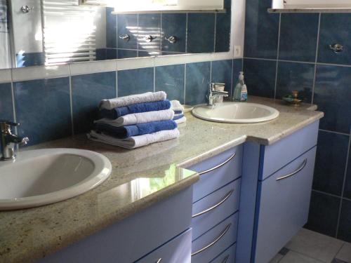 ein Badezimmer mit 2 Waschbecken und einem Spiegel in der Unterkunft Gite de la Lisière du Bois in Ueberstrass