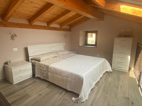 a bedroom with a white bed and a wooden floor at Casa Dell’Angelo Serafino in Castelnuovo Magra