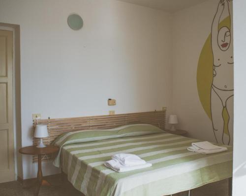 1 dormitorio con 1 cama con una pintura en la pared en Albergo delle Ondine, en Tellaro