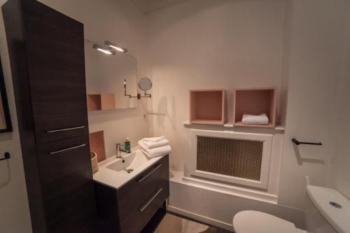 La salle de bains est pourvue d'un lavabo, de toilettes et d'un miroir. dans l'établissement MAISON RENARD, à Béthune