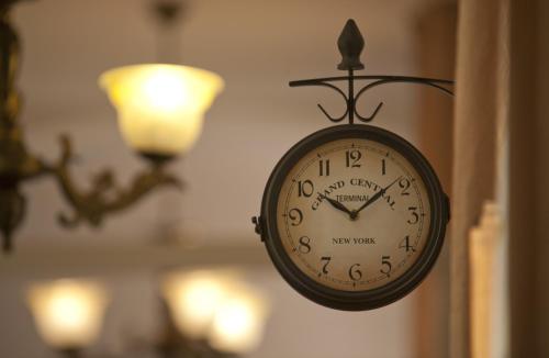 a clock hanging on a wall with a light at Maksimilian Osijek in Osijek