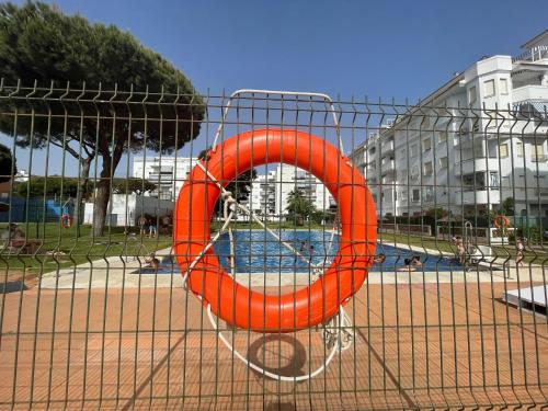 an orange life saving ring in a swimming pool at Cosy 2BR flat in Nuevo Portil city centre in El Portil