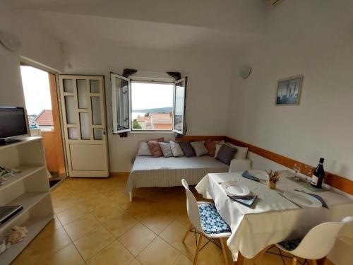 a living room with a bed and a table and chairs at Apartments Jerko in Ražanj