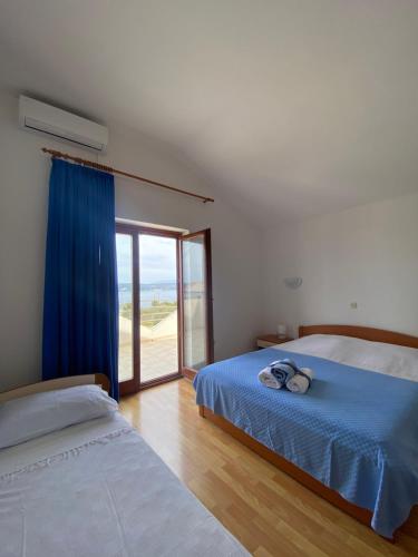 1 dormitorio con 2 camas y ventana grande en Apartments Mikecin en Novigrad Dalmatia