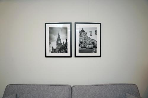 three framed photographs on a wall above a couch at The Londoner Hotel Sliema in Sliema