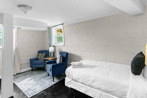 a bedroom with a bed and two blue chairs at 10 Mins to Downtown Modern in Magic City- Unit B in Birmingham
