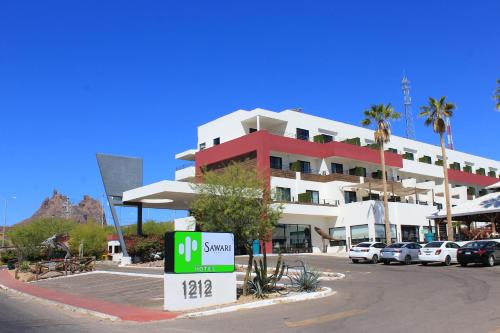 un edificio con un cartello di fronte a un parcheggio di Sawari Hotel a San Carlos