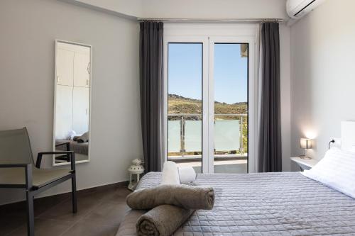 een slaapkamer met een groot bed en een raam bij Nereides - Skinaria Beach Apartment in Damnoni