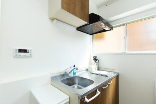 a small kitchen with a sink and a refrigerator at Amber Iidabashi - Vacation STAY 90475v in Tokyo