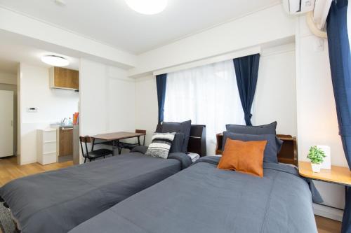 two beds in a small room with a table at Amber Iidabashi - Vacation STAY 90475v in Tokyo