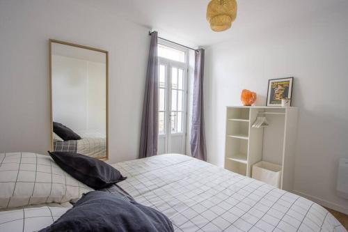 ein Schlafzimmer mit einem Bett und einem großen Spiegel in der Unterkunft Appartement avec terrasse et parking, à Meaux in Meaux
