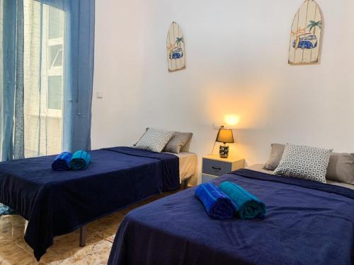 two beds in a room with blue sheets on them at Apartamento La Menia - Cabo Roig in Orihuela Costa