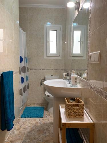a bathroom with a sink and a toilet and a mirror at Apartamento La Menia - Cabo Roig in Orihuela Costa