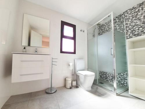a bathroom with a toilet and a glass shower at Piscina & Wifi. SUNNY apartement, swimming pool. in Caleta De Fuste