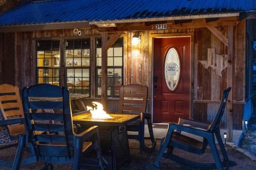 Ein Tisch mit Stühlen und ein Feuer vor einem Gebäude in der Unterkunft Pet Friendly! Hot Tub, 2mins from Main, Fire Pit in Fredericksburg