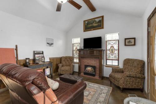 a living room with a couch and a fireplace at Pet Friendly Treehouse Vibe with Hot Tub & Fire Pit in Fredericksburg