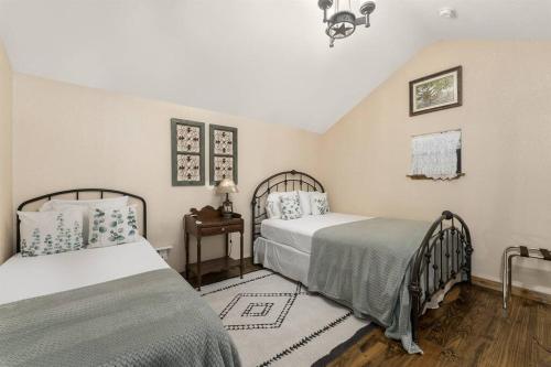 1 dormitorio con 2 camas y mesa con lámpara en Pet Friendly! Hot Tub, 2mins from Main, Fire Pit, en Fredericksburg