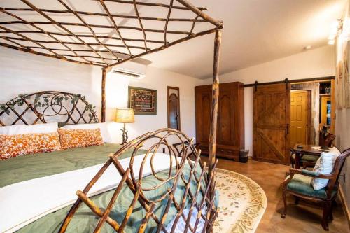 1 dormitorio con 1 cama grande con dosel de madera en Pet Friendly! Hot Tub, 2mins from Main, Fire Pit, en Fredericksburg