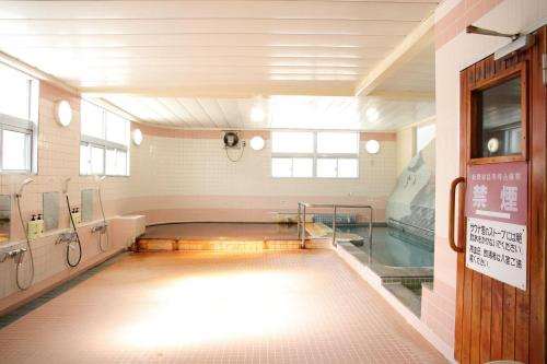 a swimming pool in a gymnasium with a swimming pool at Pinneshiri onsen Hotel Bogakuso - Vacation STAY 31617v in Pinneshiri