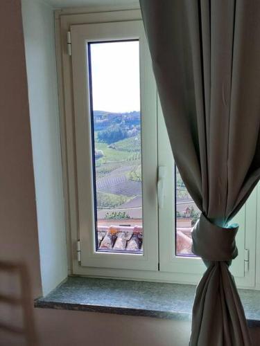 a window with a curtain in a room with a view at L'angolo delle rose in Govone
