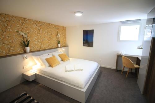 1 dormitorio con cama blanca y almohadas amarillas en Chambres4you, en Namur