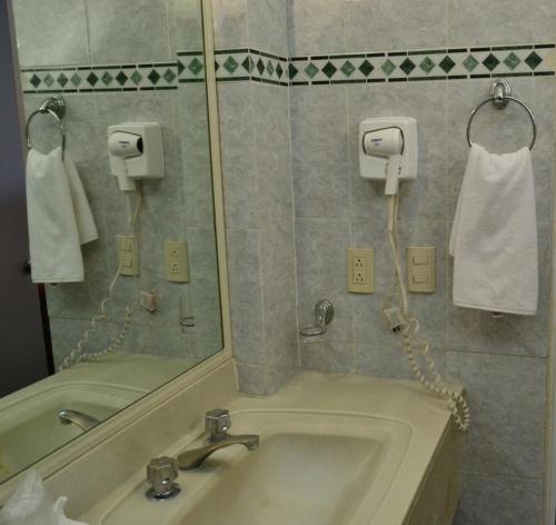 La salle de bains est pourvue d'un lavabo et d'un miroir. dans l'établissement Hotel Zafra, à Torreón