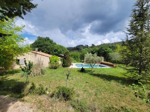 un jardín con piscina y una casa en Villa climatisée piscine, en Cadenet