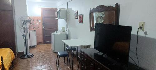 sala de estar con TV de pantalla plana y mesa en Tutu House en Salta