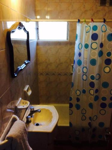 baño con lavabo y cortina de ducha en Tutu House en Salta