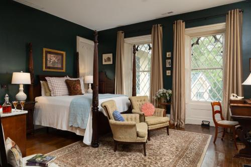 a bedroom with a bed and a chair at Inn at Woodhaven-In the Heart of the Bourbon Trail-Over 12 Distilleries Nearby in Louisville