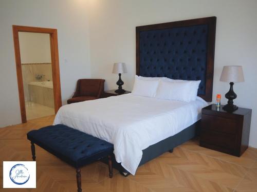 ein Schlafzimmer mit einem großen Bett und einem Stuhl in der Unterkunft Villa Anastasia in Siavonga