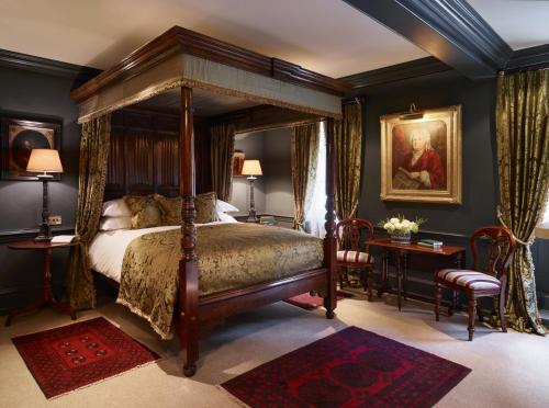 1 dormitorio con cama con dosel y escritorio en Batty Langley's, en Londres