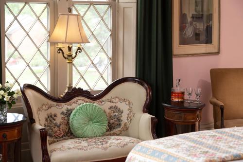 a chair with a pillow on it in front of a window at Inn at Woodhaven-In the Heart of the Bourbon Trail-Over 12 Distilleries Nearby in Louisville