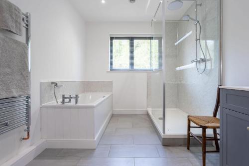 ein Bad mit einer Badewanne, einem Waschbecken und einer Dusche in der Unterkunft Sunset Barn in Dulverton