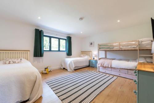 1 Schlafzimmer mit 2 Etagenbetten und einem Teppich in der Unterkunft Sunset Barn in Dulverton
